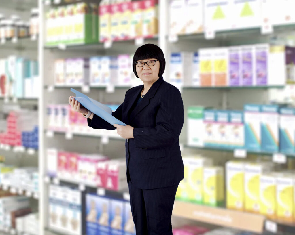 A woman holding a paper in front of shelves.